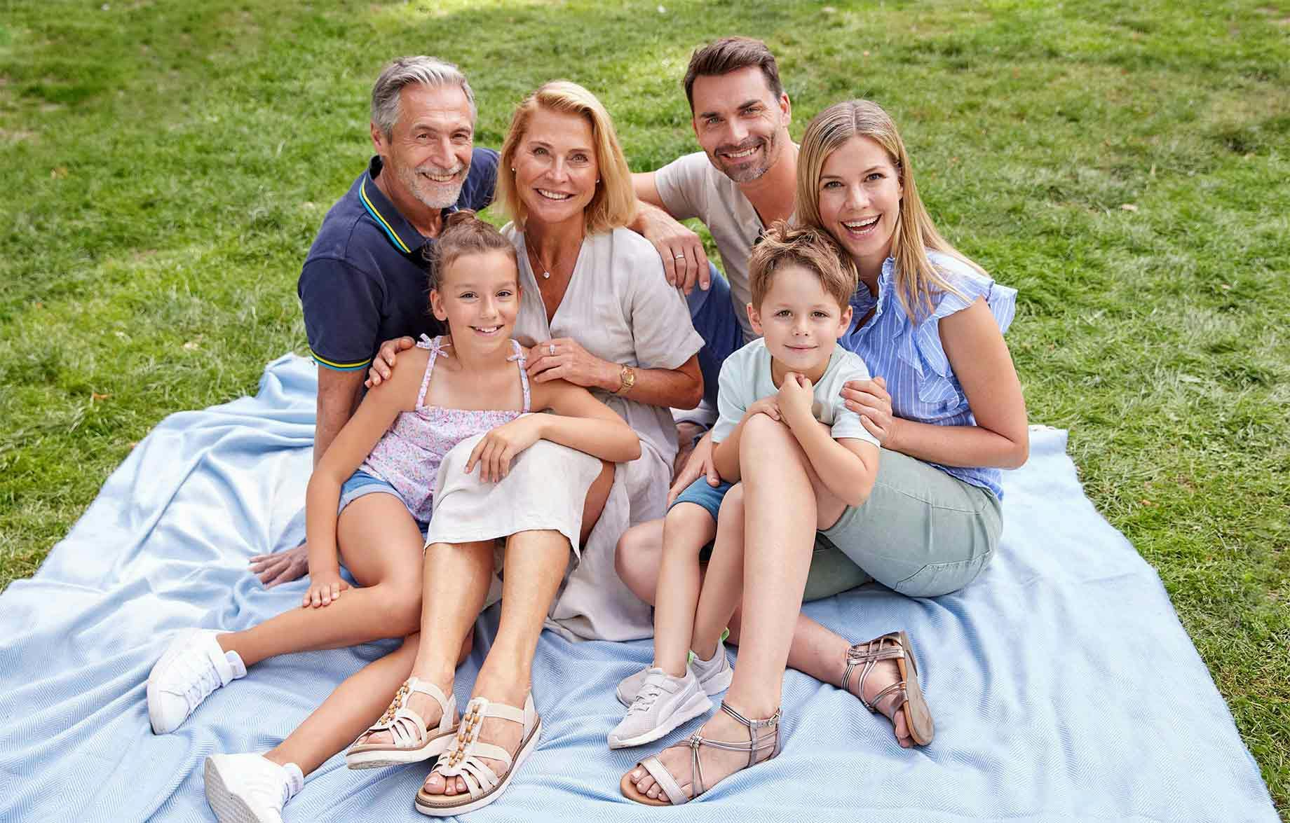 Schuhpark froehliche Familie auf Picknickdecke